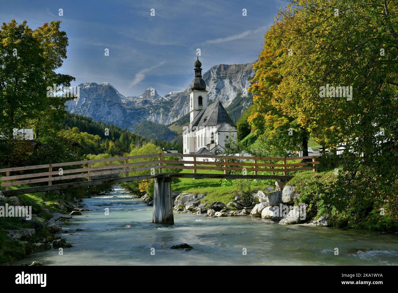 Die idyllische Kirche von Ramsau in den Berchtesgadener Alpen für Herbststimmung und den kleinen Gebirgsfluss Stockfoto