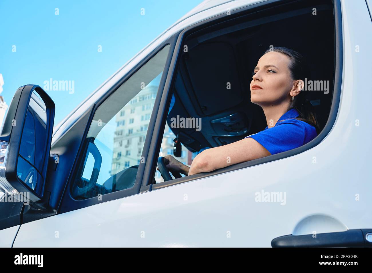Schöne Frau professionelle LKW-Fahrer sitzen innerhalb Cargo-Auto während der Lieferung. Frauen in männlich dominierten Branchen und Berufen Stockfoto
