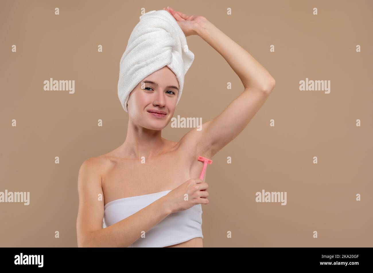 Junge Frau, die sich im Achselbereich rasieren kann Stockfoto