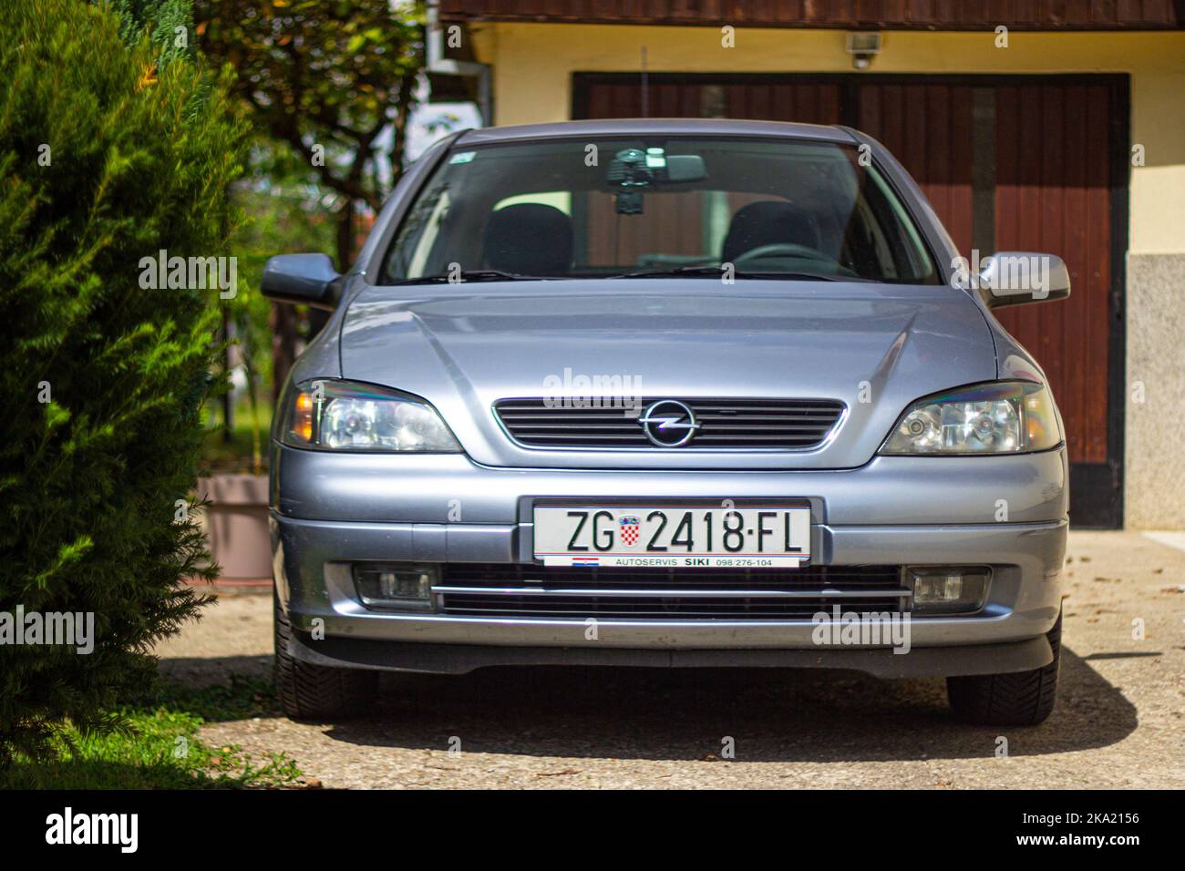 Silberblau 2002 Opel Vauxhall Astra geparkt vor der Hausgarage an sonnigen Tag außen Stockfoto