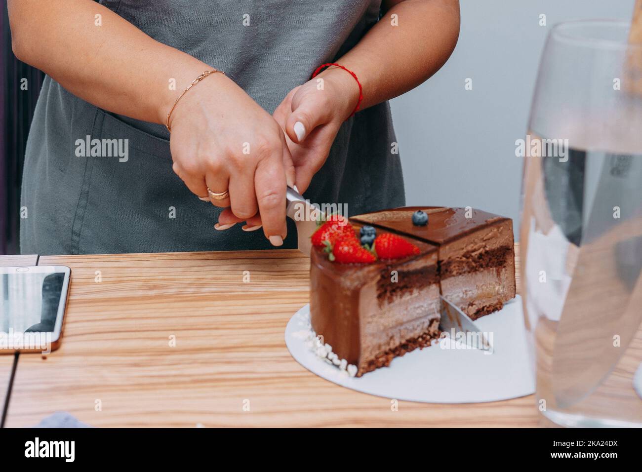 Ein Stück Schokoladenkuchen im Schnitt. Zubereitung von Mousse-Kuchen bei einem kulinarischen Meisterkurs. Kochen zu Hause, hausgemachtes Essen. Stockfoto