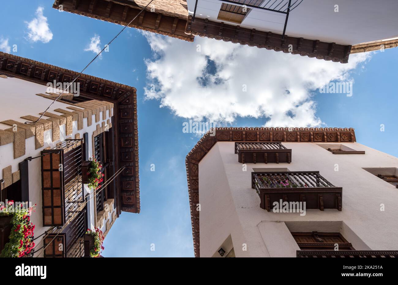 Hölzerne Dachrinnen von Häusern altes Dorf von Spanien, geschnitzte Holzschnitzerei blauen Himmel und Wolken Blick, traditionelle Architektur Gebäude Stockfoto