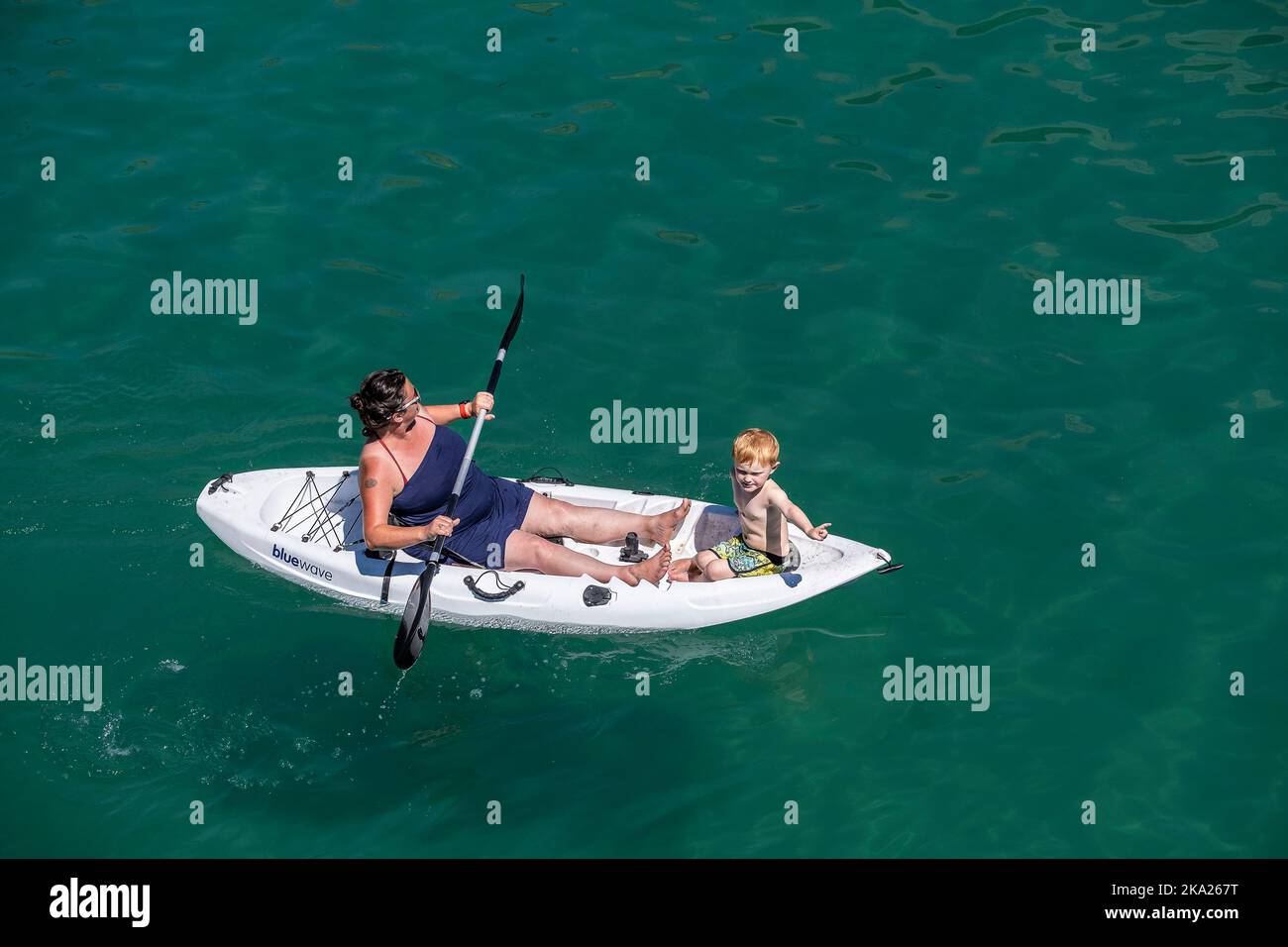 Eine Mutter und ein Kind sitzen auf einem Kajak in Newquay Bay in Cornwall in England im Vereinigten Königreich. Stockfoto