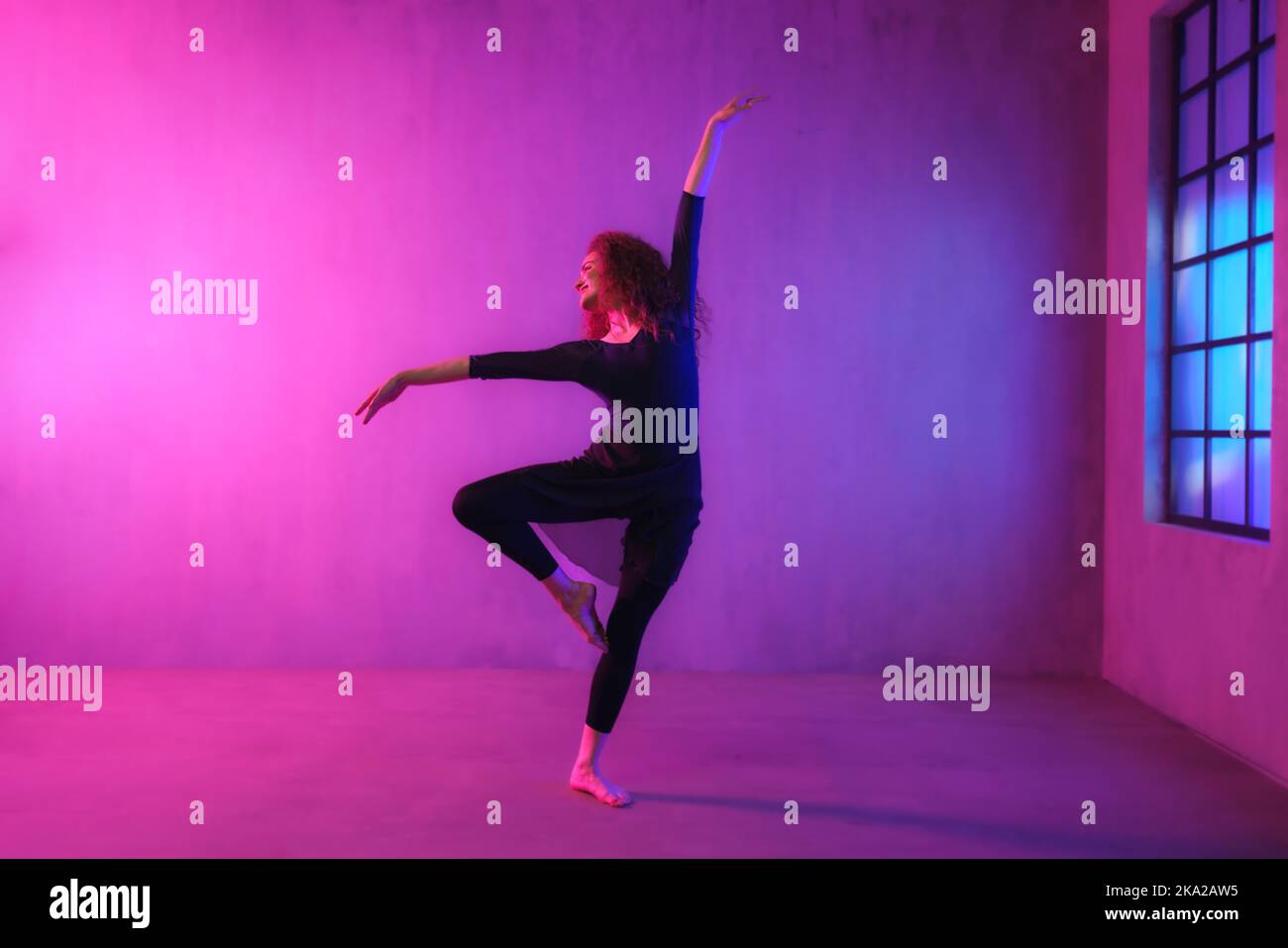 Moderner Tanz Mädchen Tänzerin tanzen in Neon-Licht dabei Gymnastik-Übungen im Studio, kopieren Raum. Stockfoto