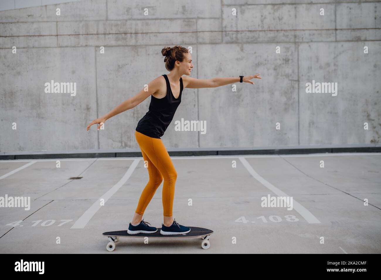 Junge Frau, die in der Stadt Skateboard fährt. Jugendkultur und Pendelkonzept. Stockfoto