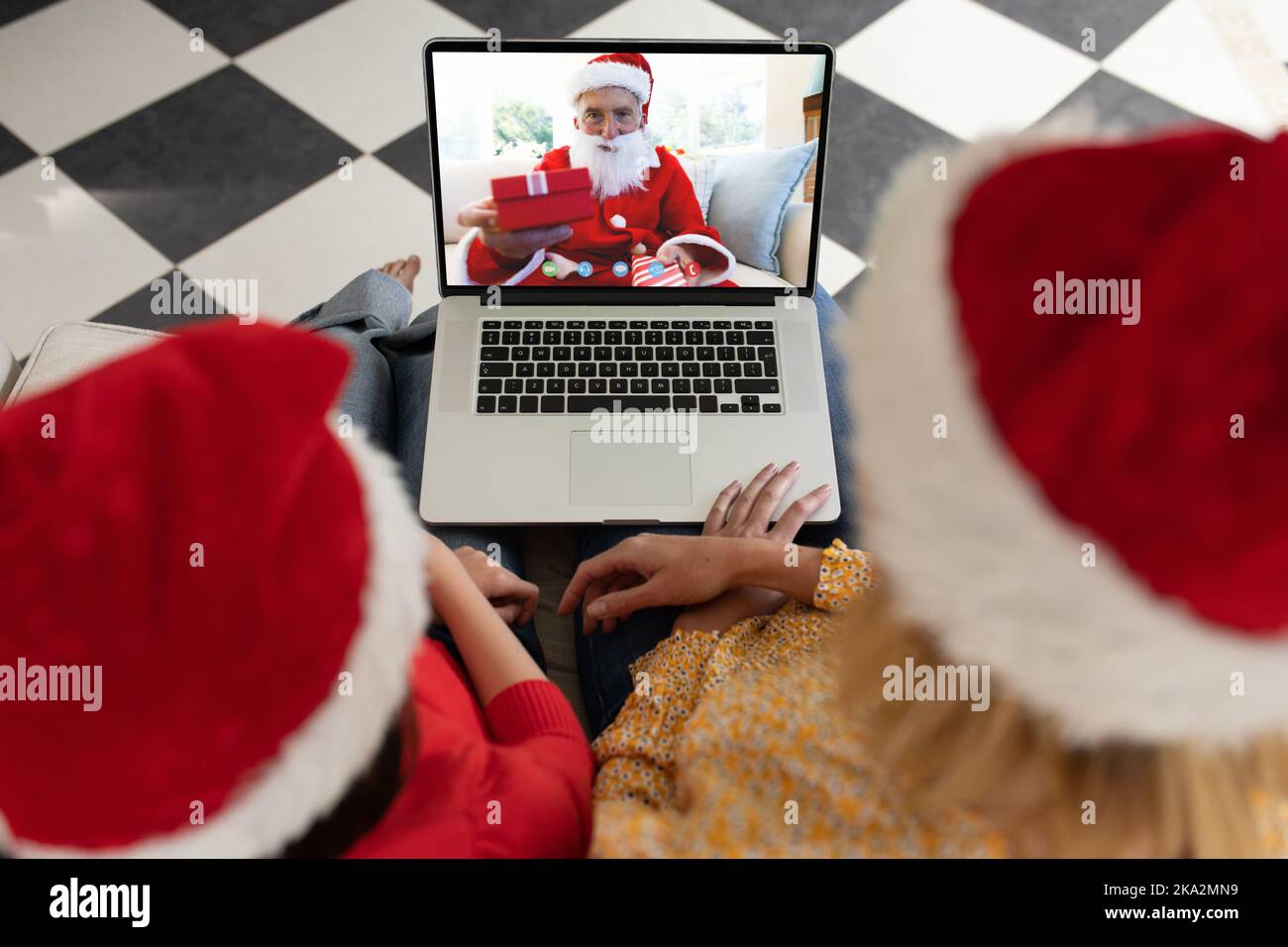 Ein vielseitiges Paar, das ein weihnachtsvideo mit einem Kaukasier im weihnachtsmann-Kostüm hat Stockfoto