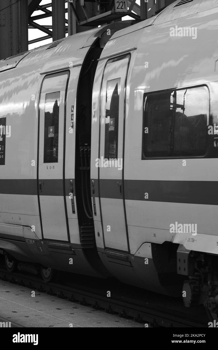 Eine Graustufen-Nahaufnahme des Wagens und der Tür eines deutschen Schnellzugs in Köln Stockfoto