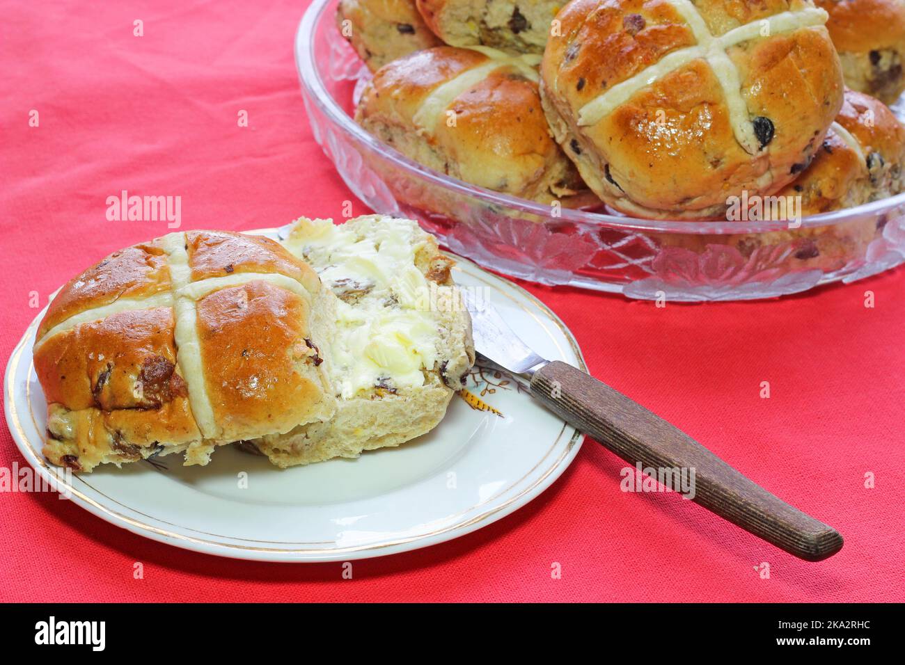 Heiße Brötchen zu Ostern mit Butter. Johannisbeeren und gemischte Trockenfrüchte in den Brötchen. Stockfoto