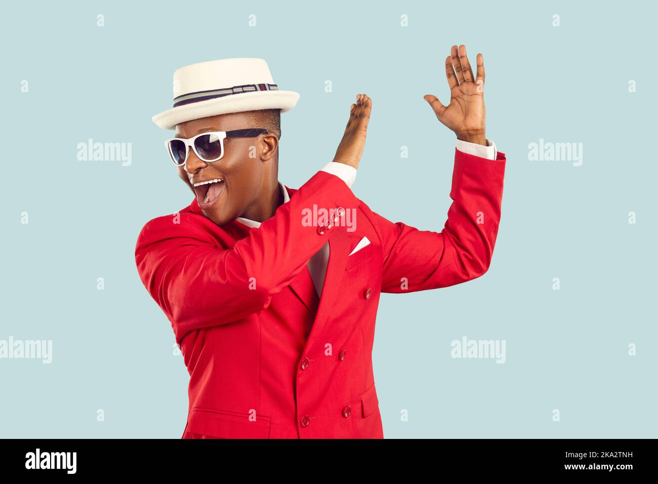 Junger afroamerikanischer Mann, roter Unterhaltungsanzug, brüllend und klatschend, tanzend Stockfoto