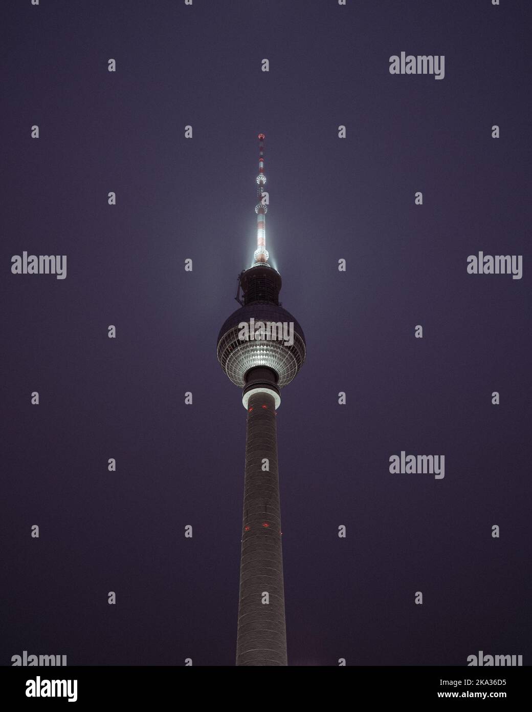 Eine vertikale Aufnahme des Berliner Fernsehturms in der Nacht. Stockfoto