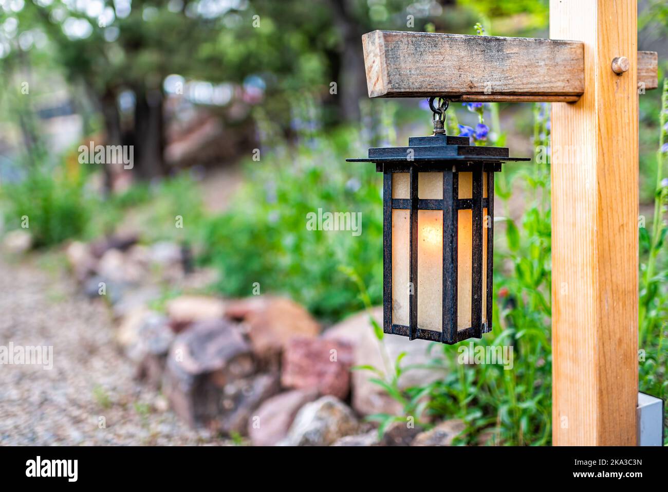 Hängende Laternen-Lampe im japanischen Stil auf Holzpfosten im japanischen  Garten mit Pfad zum Tempel oder Schrein mit grünem Laub im Hintergrund  Stockfotografie - Alamy