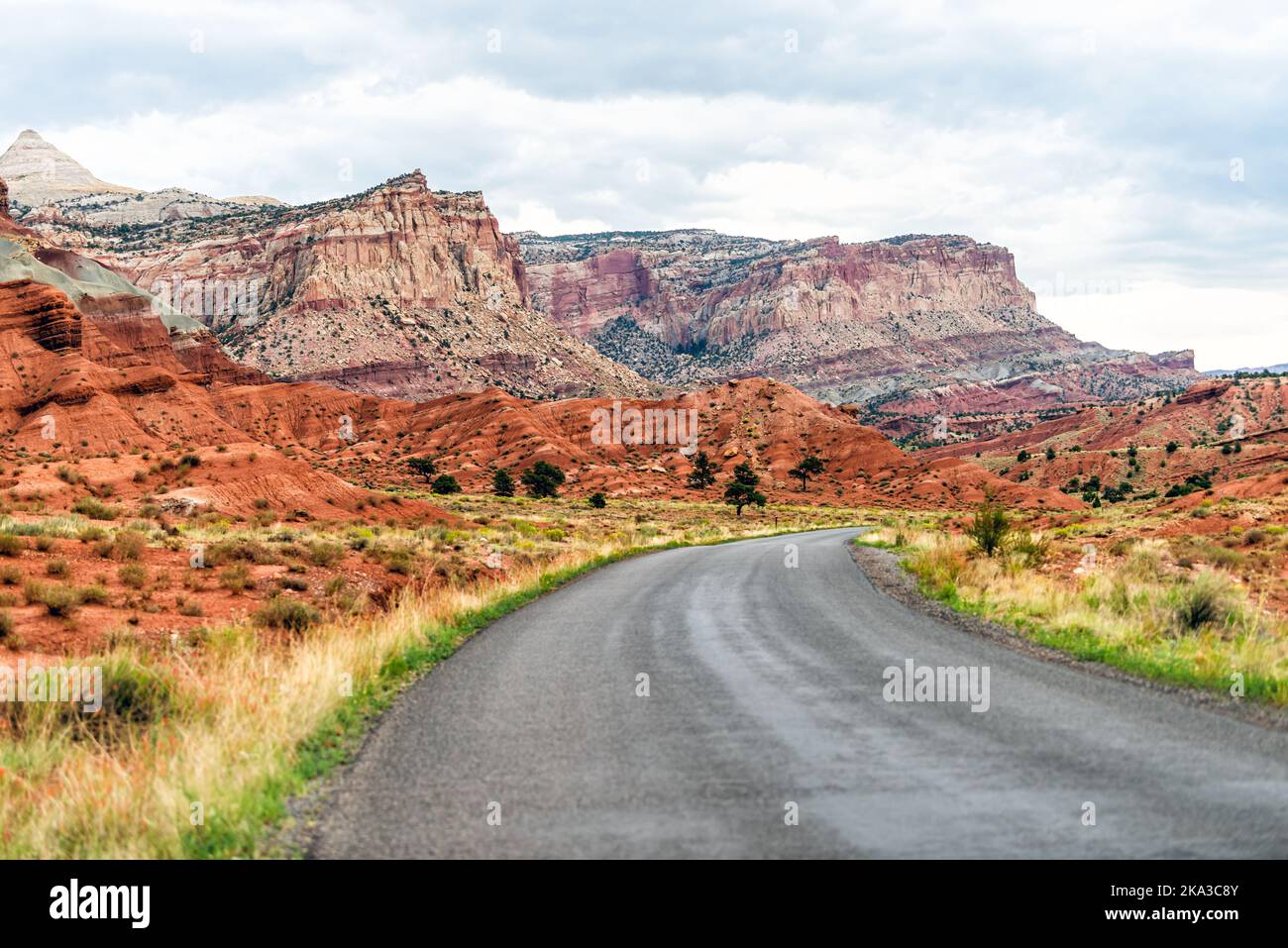 Blick auf den Highway im Capitol Reef National Monument mit gepflasterter Straße und farbenfrohen mesa-Klippen im Utah National Park ohne jemanden Stockfoto