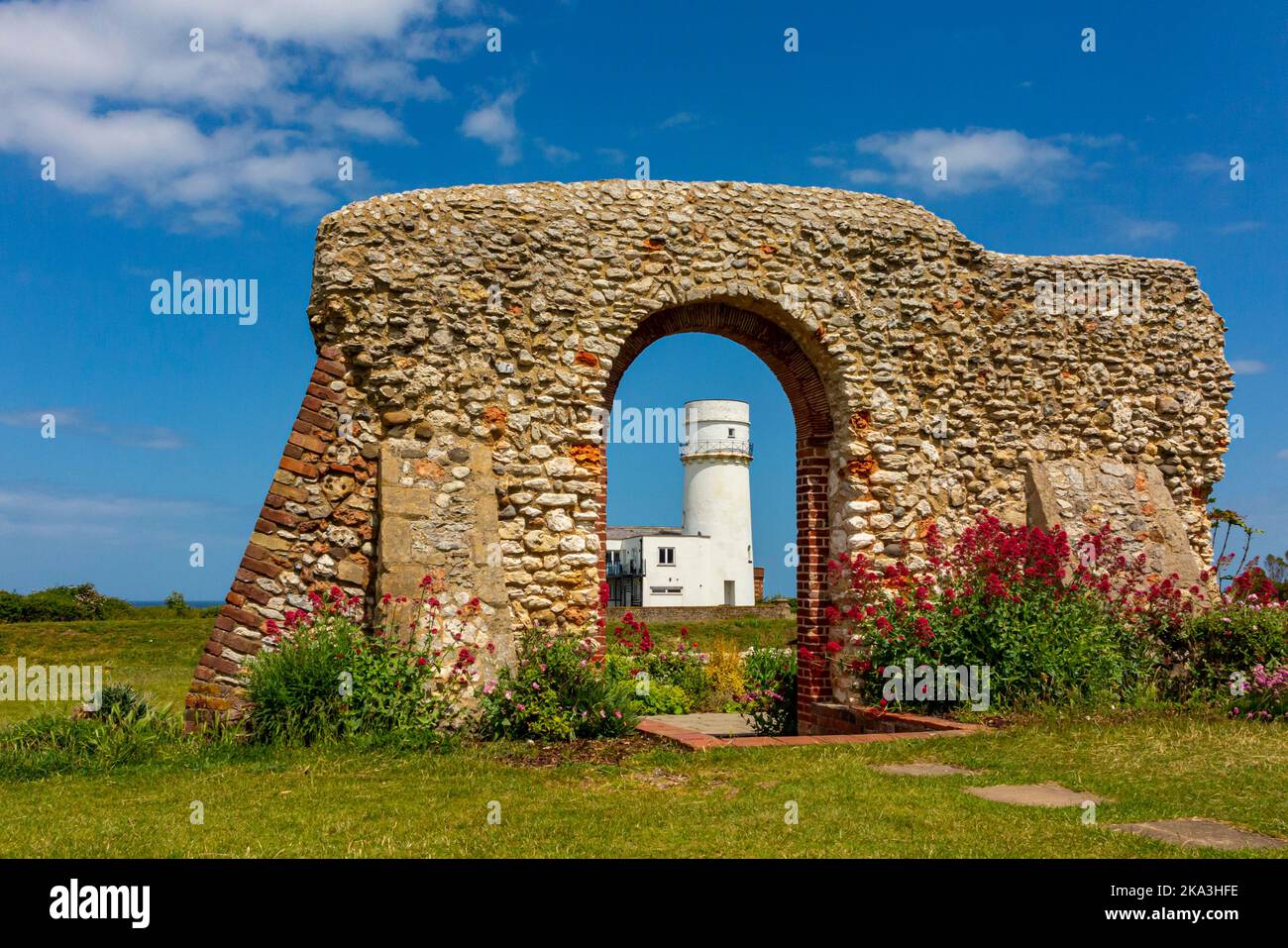 Die Ruinen der St. Edmund's Chapel, erbaut 1272, mit dem ehemaligen Leuchtturm im Hintergrund in Old Hunstanton, einem Badeort in Norfolk England. Stockfoto