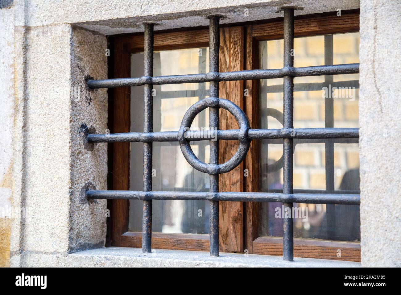 Antikes, mächtiges, geschmiedetes Gitter auf einem kleinen Fenster. Stockfoto
