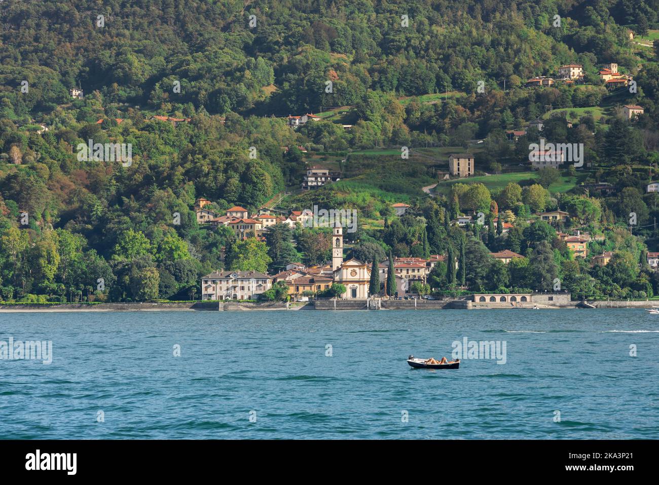 Ferienpaar, Blick im Sommer von zwei sorglosen Menschen in einem Ruderboot treiben auf dem Comer See an einem sonnigen Nachmittag, Lombardei, Italien Stockfoto
