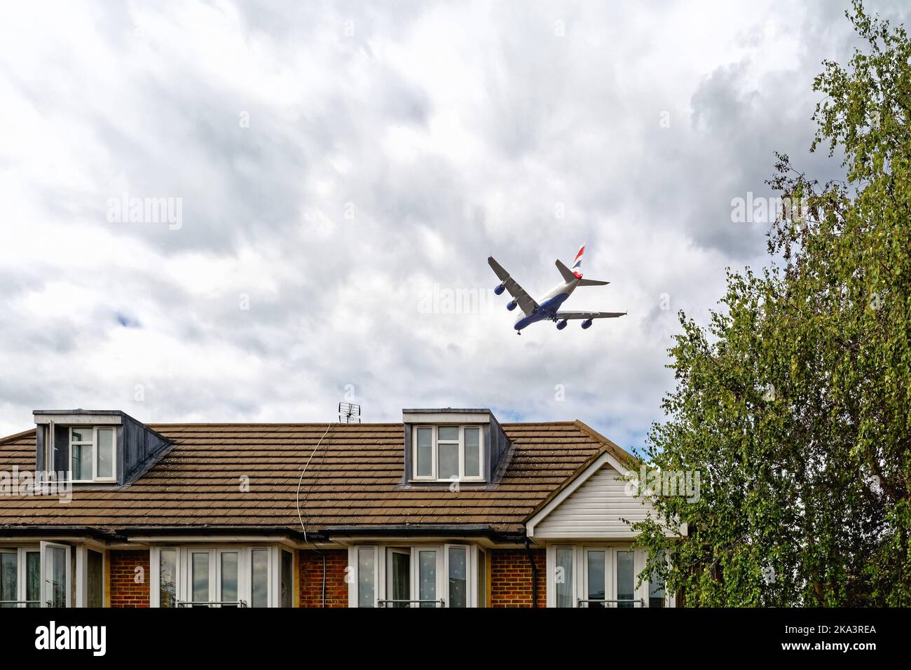 Ein Super-Jumbo-Passagierflugzeug von British Airways A380, das in geringer Höhe über Vorstadthäusern in Hounslow fliegt, auf dem Weg zum Flughafen Heathrow in Großbritannien Stockfoto
