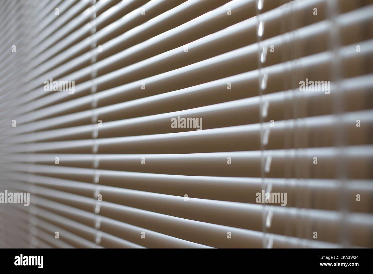 Jalousien im Büro. Details zur Innenausstattung. Das Fenster ist vor Licht geschlossen. Schutz vor scharfem Sonnenlicht. Jalousien am Fenster. Stockfoto
