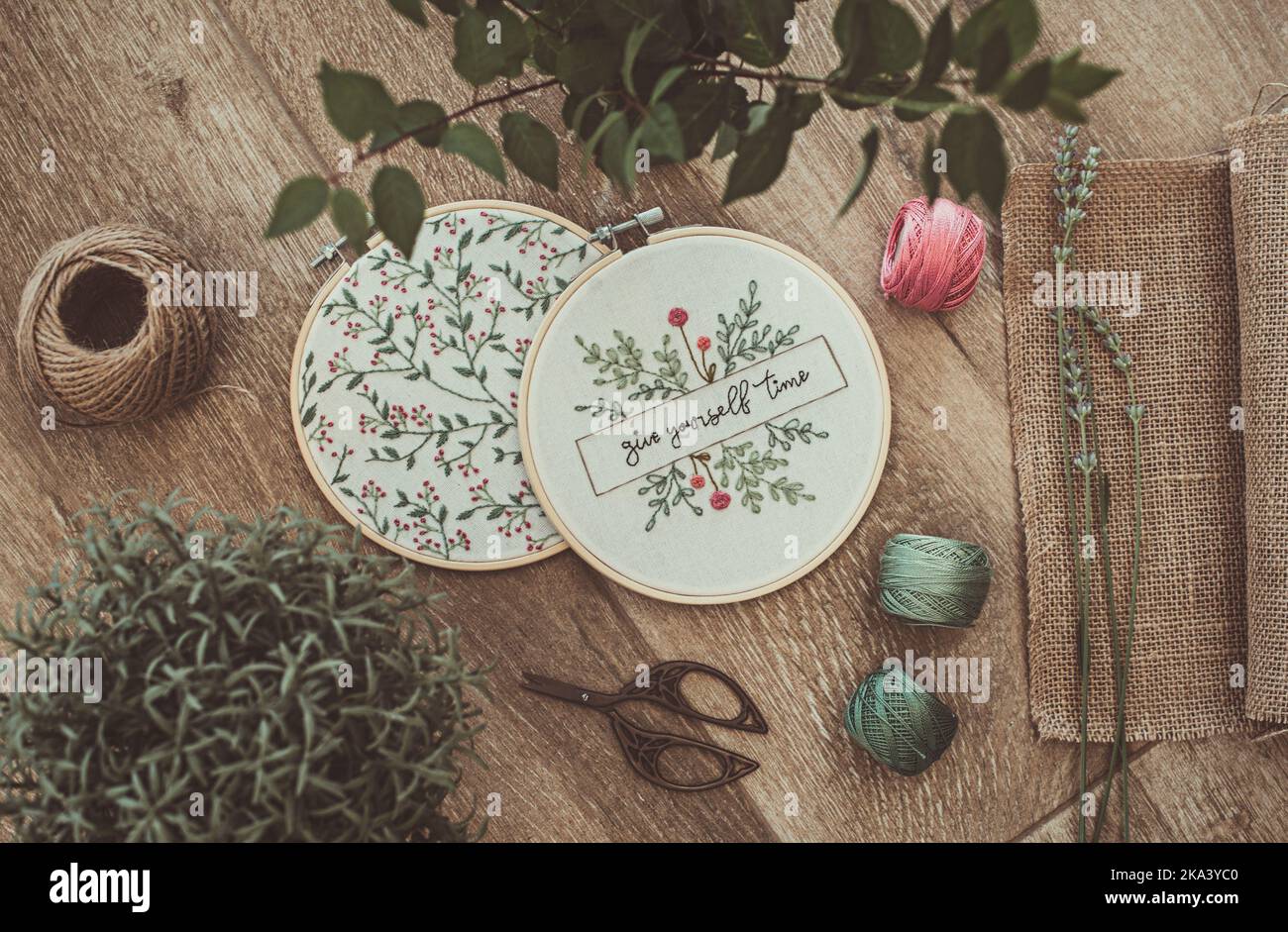 Overhead-Ansicht von zwei Stickereien Reifen mit Blumenschmuck und die Worte geben sich Zeit Stockfoto