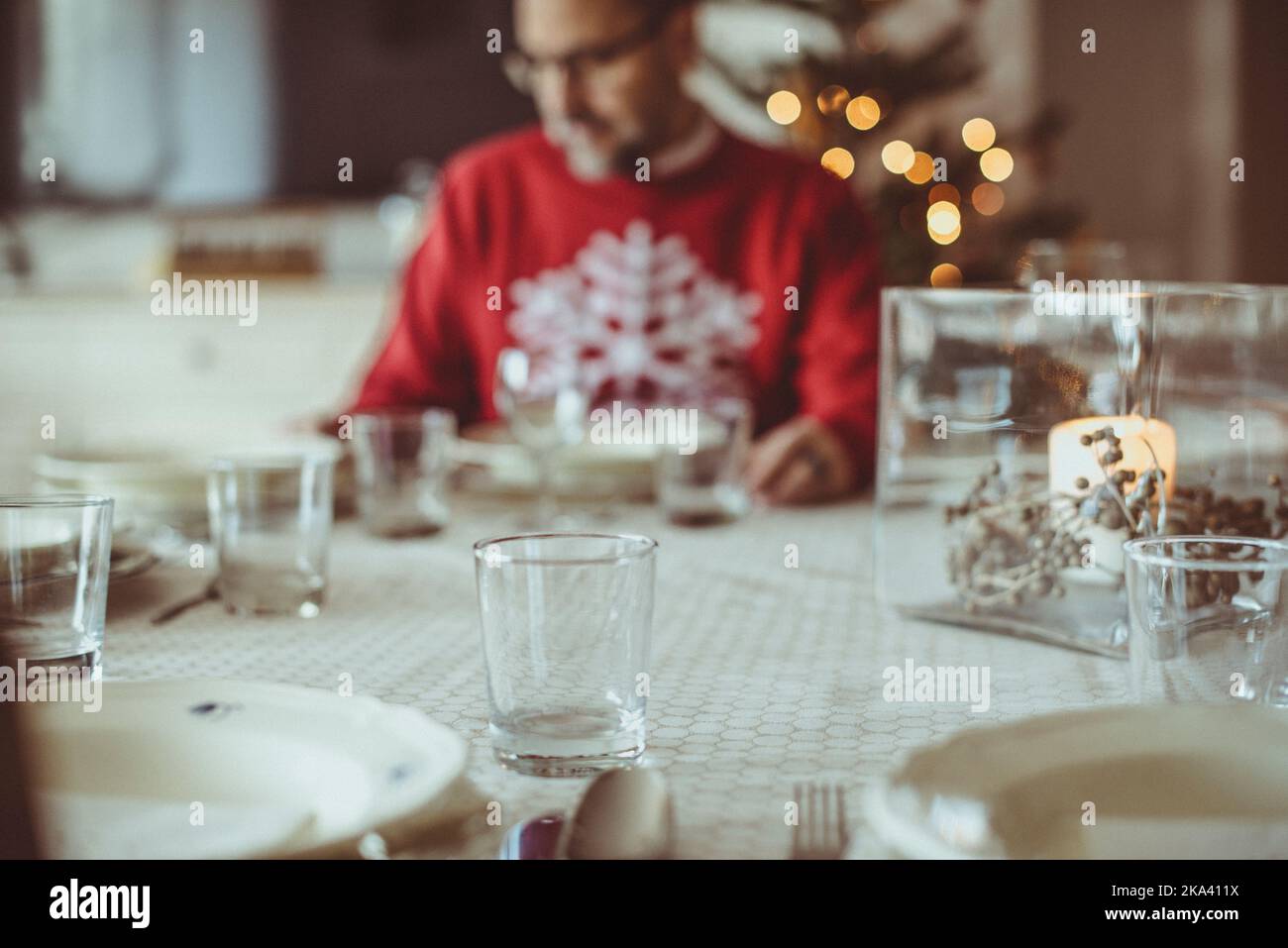 Mann, der zu Weihnachten an einem Esstisch sitzt und zum Abendessen bereit ist Stockfoto