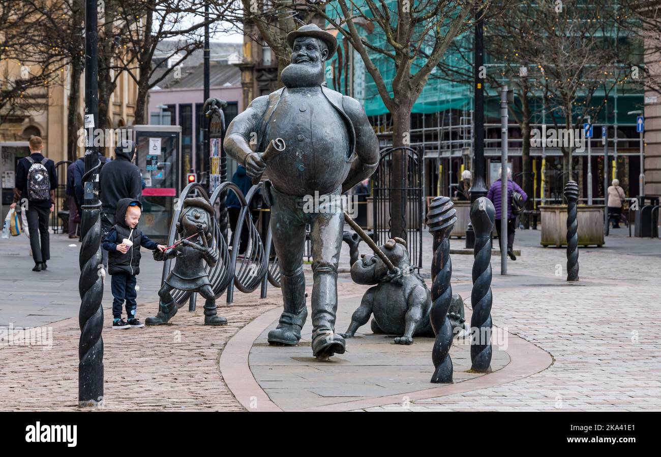 Kind, das sich die skurrile Bronzeskulptur der Comicfigur Desperate Dan von Beano, Minnie the Minx & Pug, Dundee, Schottland, Großbritannien, ansieht Stockfoto