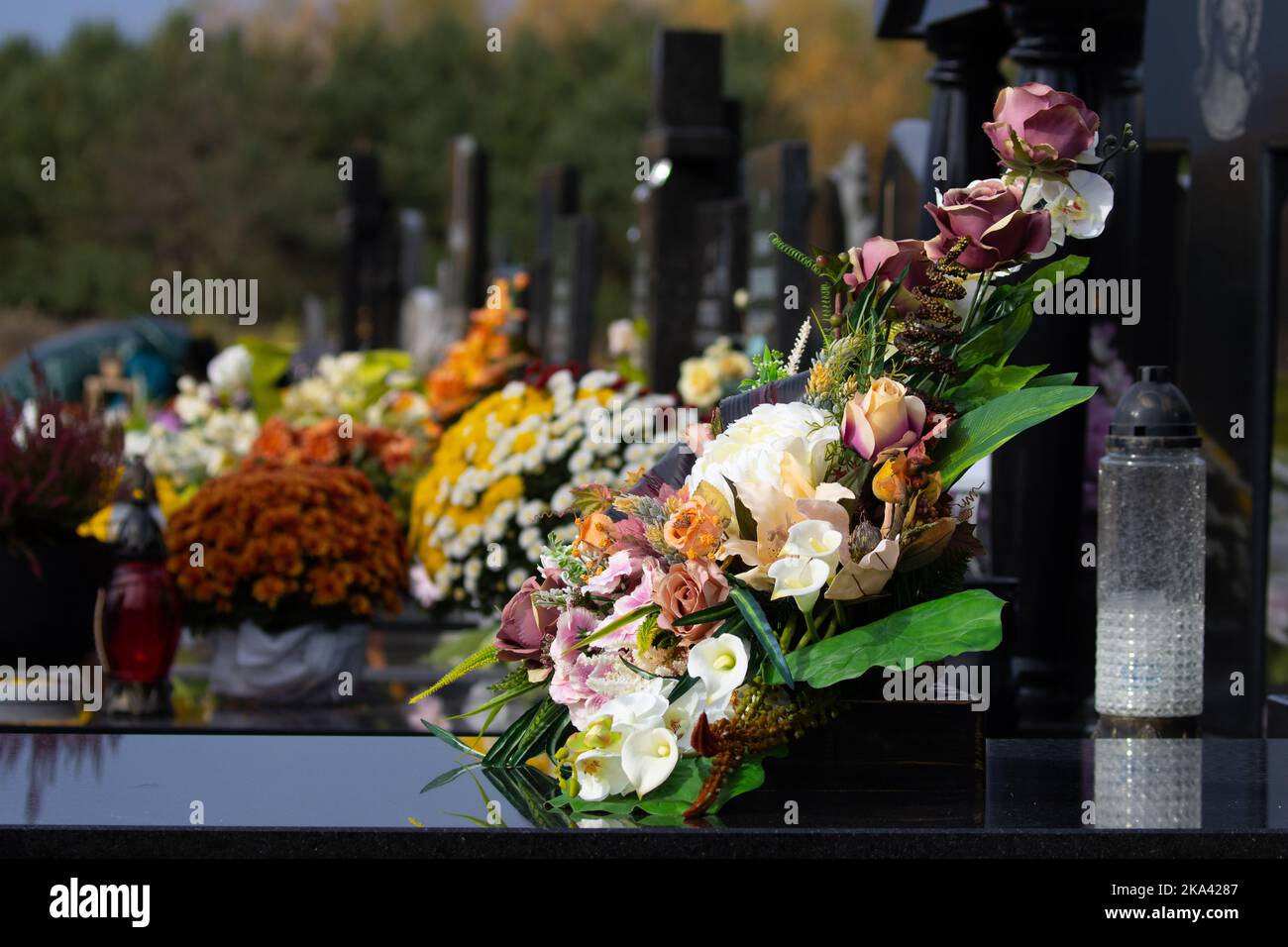 Blumen auf dem Grab. Fest der Toten. Ein Blumenstrauß auf dem Friedhof, Stockfoto