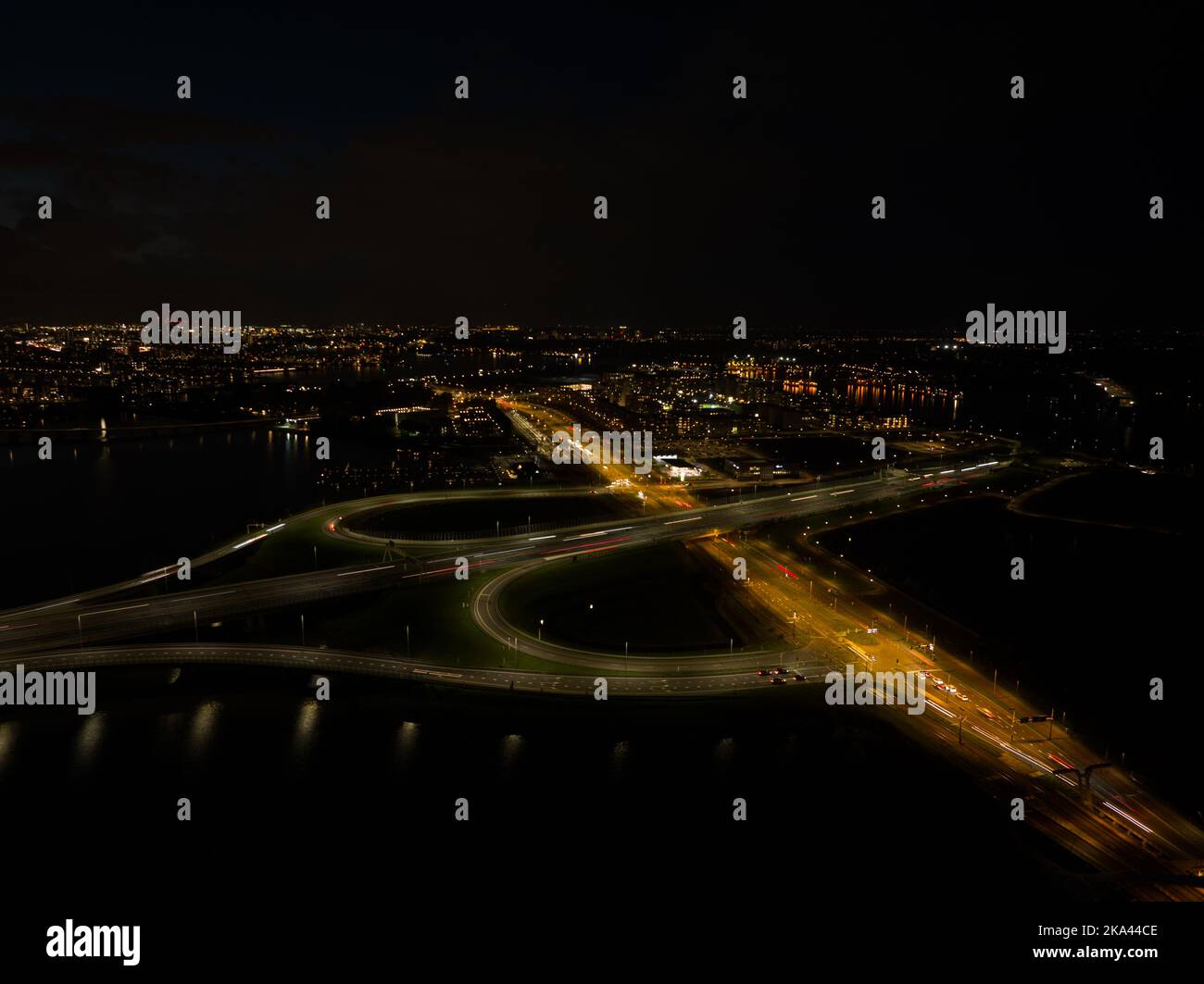 A10 Straßenverkehr in der Nacht. Autobahninfrastruktur im Dunkeln Licht des dynamischen, sich bewegenden Verkehrs auf der Straße bei Amsterdam IJburg in den Niederlanden Stockfoto