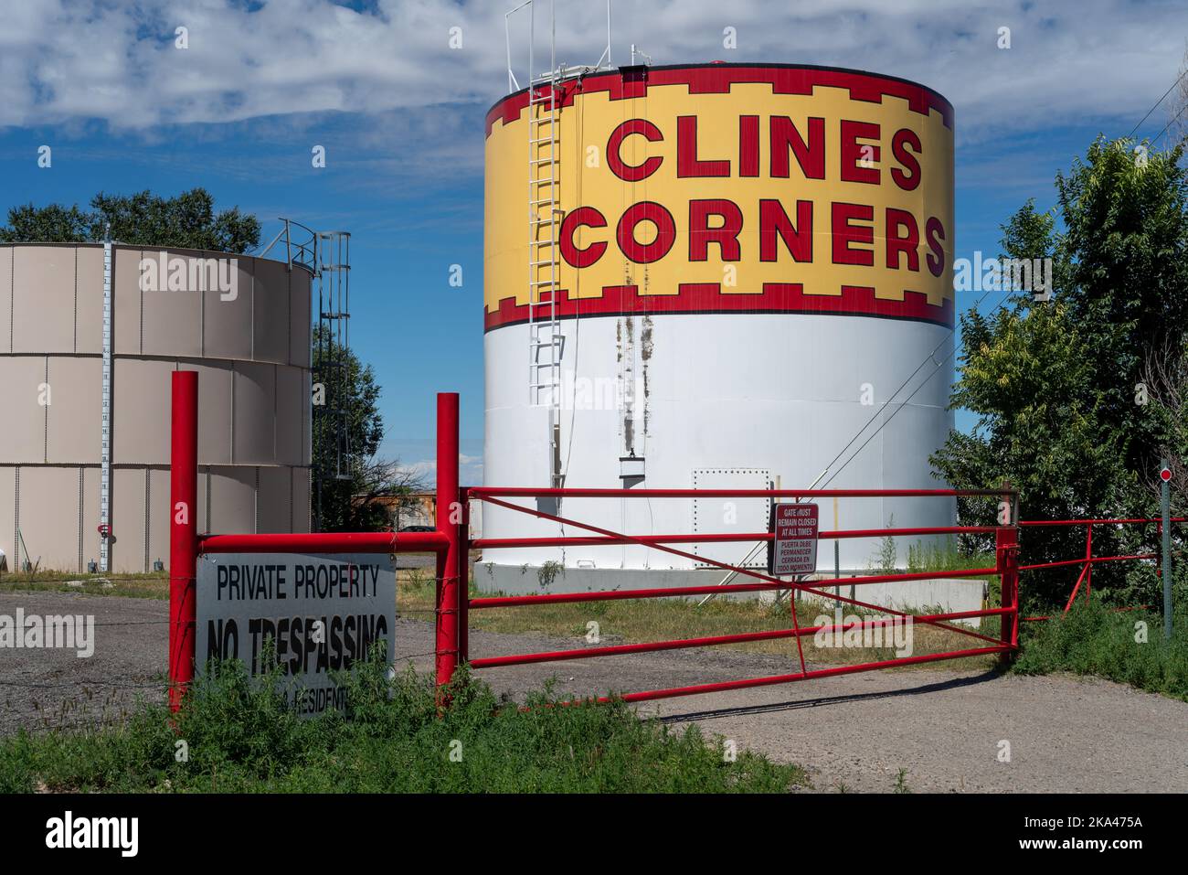 Ein großer Tank, die obere Hälfte rot und gelb mit den Worten Cline Corners in großen Blockbuchstaben, Clines Corners, New Mexico. Stockfoto