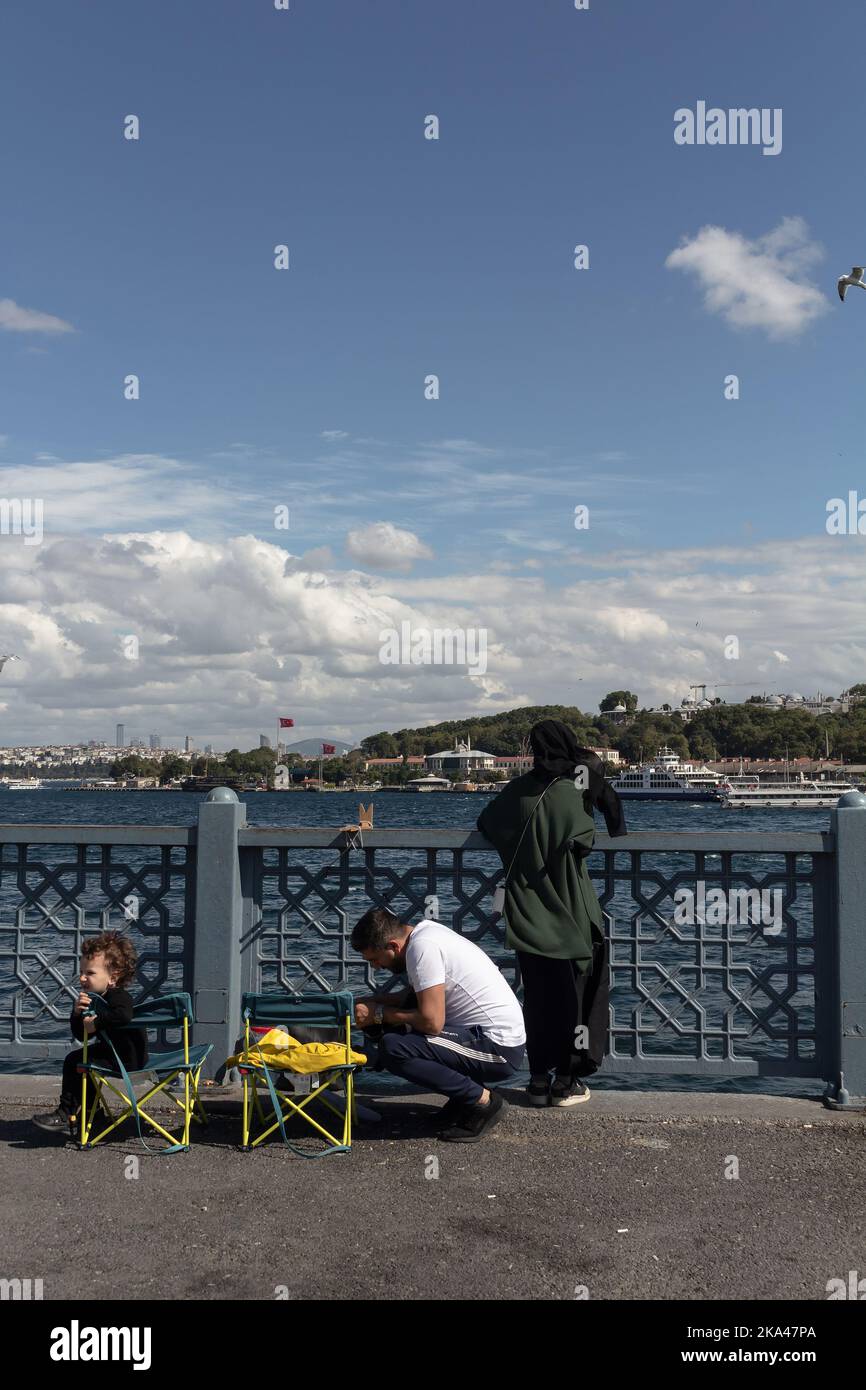 Blick auf eine Familie, die auf der Galata-Brdge in Istanbul angeln kann. Es ist ein sonniger Sommertag. Stockfoto