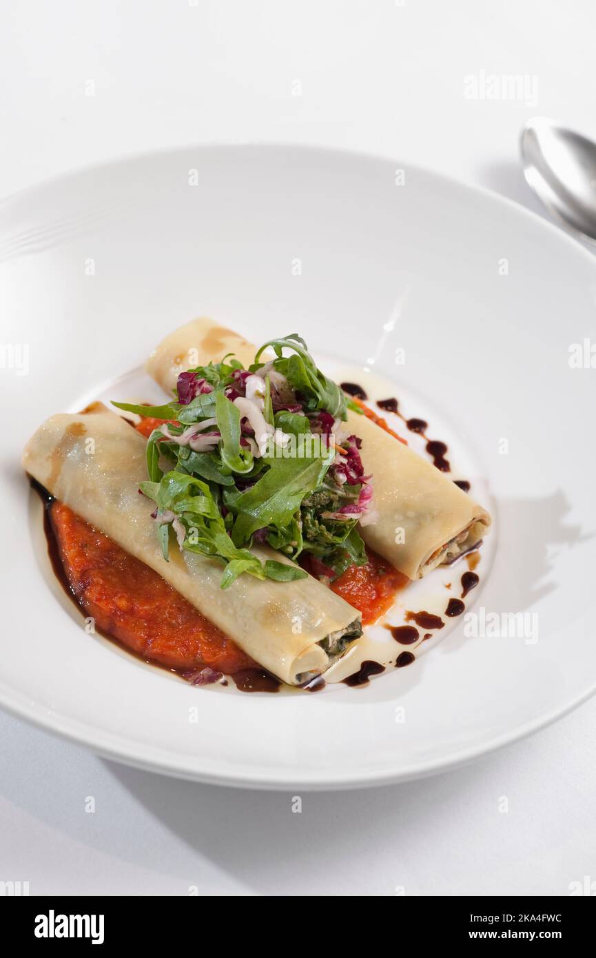 Cannelloni mit Ricotta und Spinat serviert mit Rucola, Radicchio und Balsamico-Vinager Stockfoto