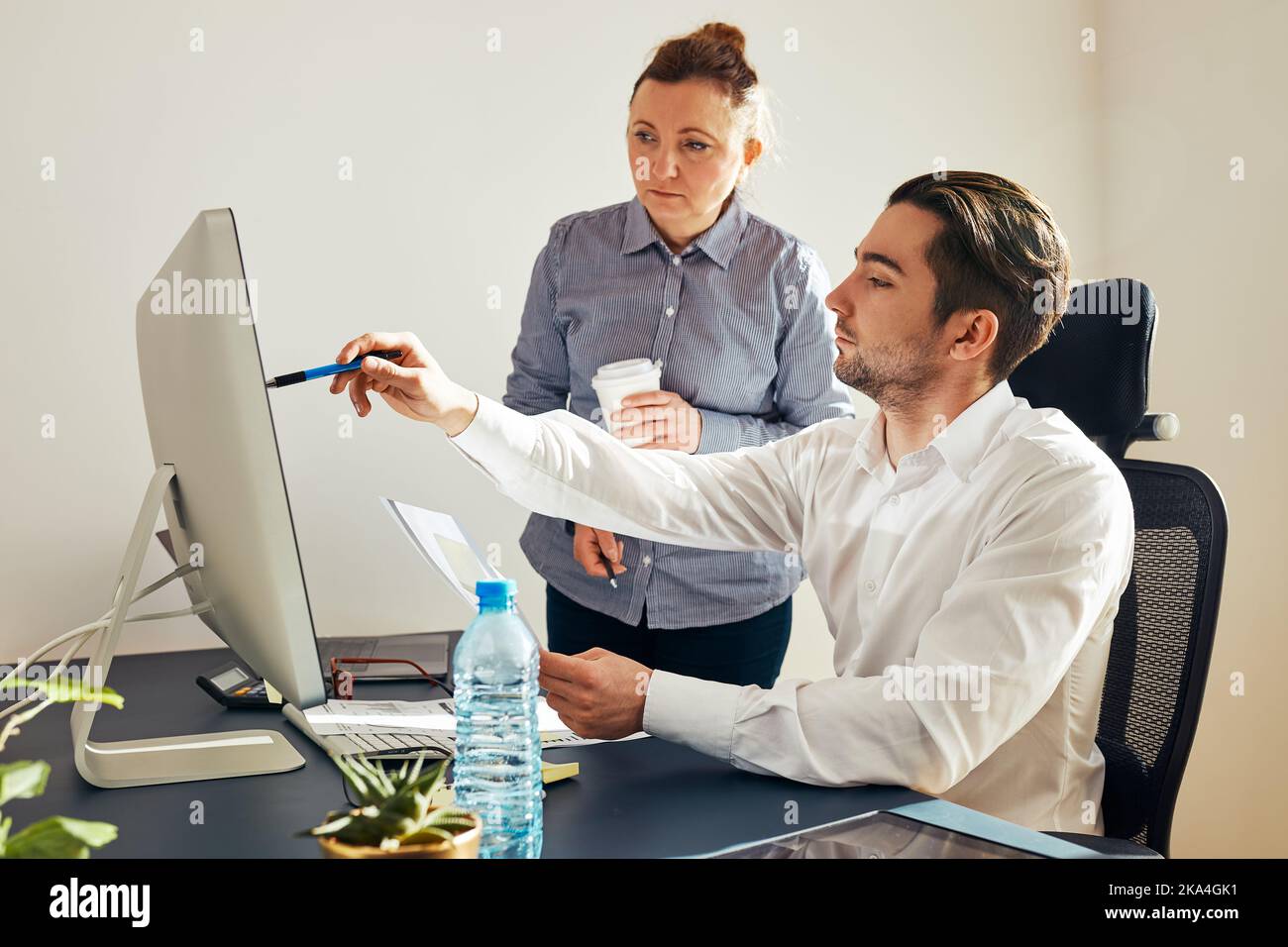Zwei Geschäftsleute diskutieren Finanzdaten am Computer. Geschäftsfrau, die mit einem männlichen Kollegen im Büro zusammenarbeitet. Menschen Unternehmer arbeiten mit char Stockfoto