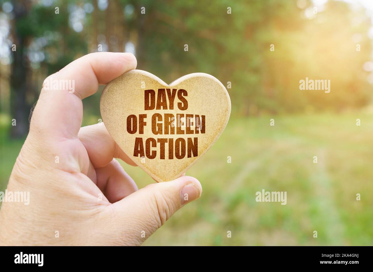 Ökologisches Konzept. In den Händen eines Mannes befindet sich eine Tablette in Form eines Herzens, auf dem es steht - Days of Green Action Stockfoto