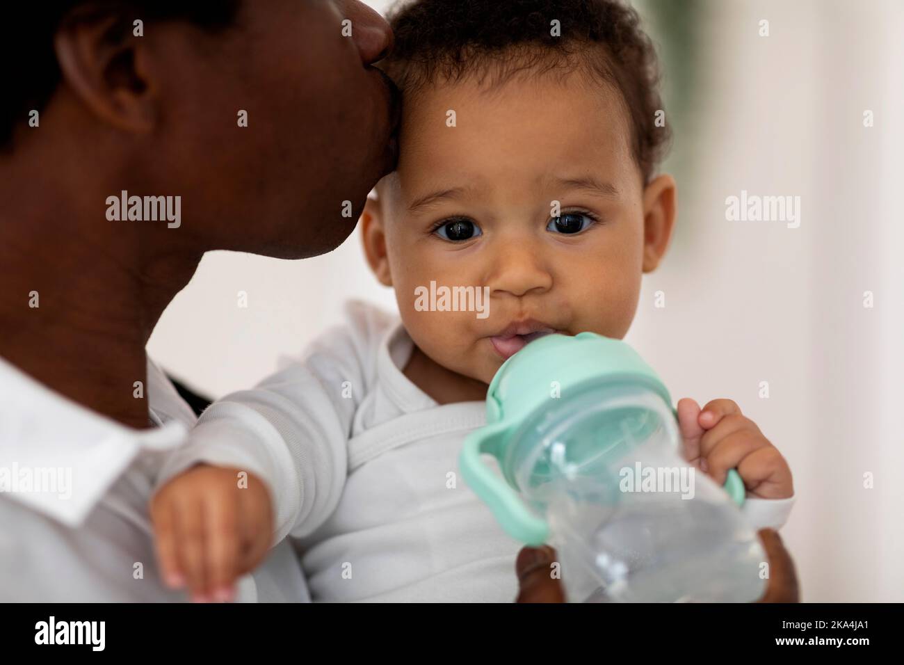 Nahaufnahme Porträt Von Dursty Adorable Black Infant Boy Trinkwasser Aus Flasche Stockfoto