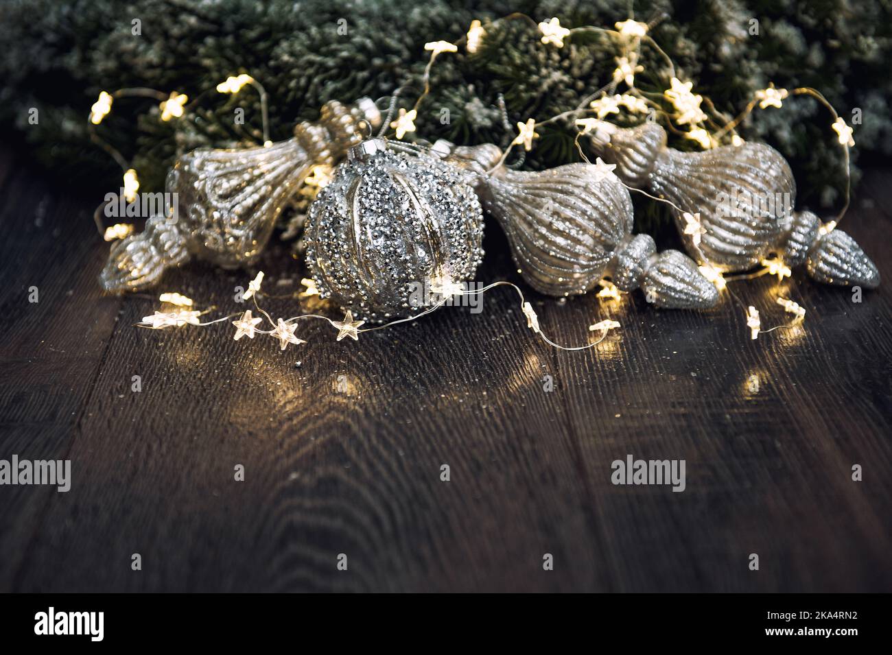Weihnachtsschmuck mit goldenen Lichtern auf dunklem Hintergrund Stockfoto