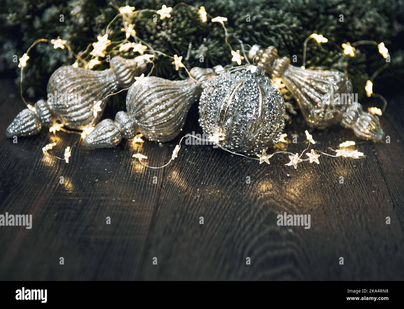 Weihnachtsschmuck mit goldenen Lichtern auf dunklem Hintergrund. Vintage getöntes Bild Stockfoto