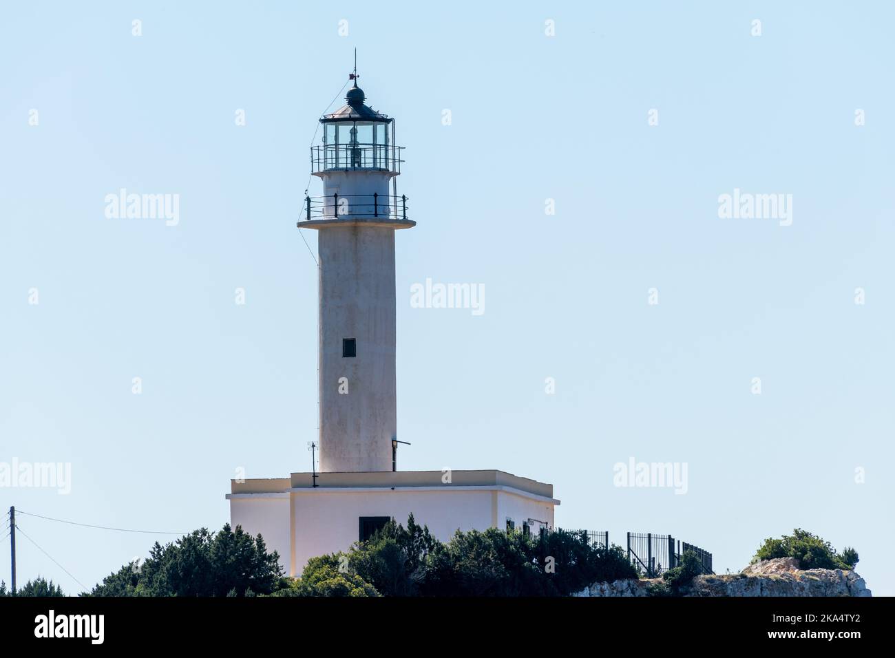 Ein weiß bemalter Leuchtturm an einem sonnigen Tag mit blauem Himmel. Stockfoto