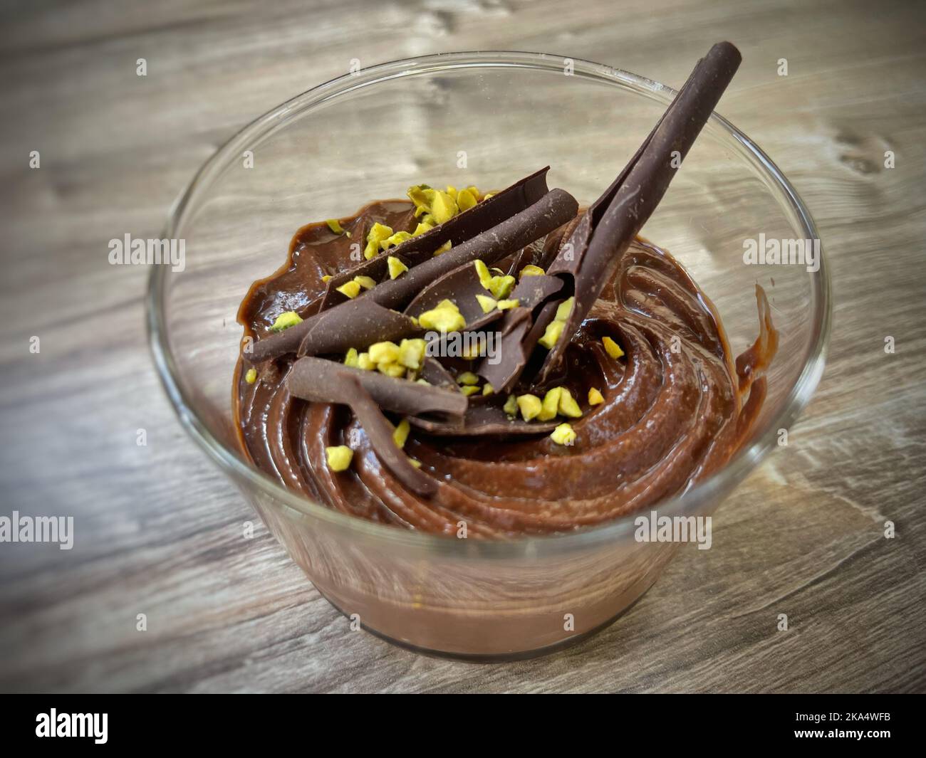 Nahaufnahme einer Schokoladenmousse mit Schokoladenlocken und Pistazien-Garnitur Stockfoto