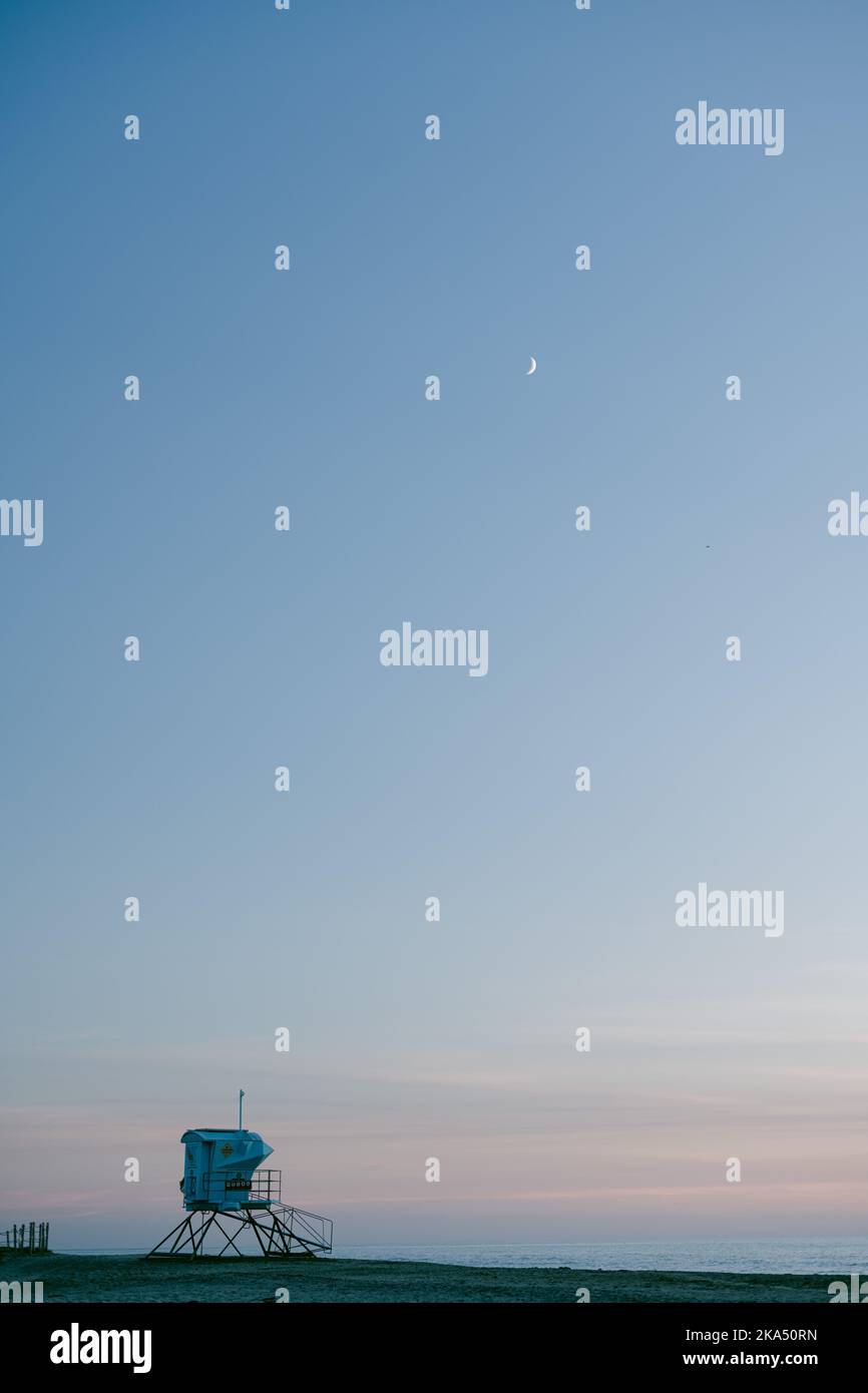 Rettungsschwimmer Turm nach Sonnenuntergang mit Mond am Himmel Stockfoto