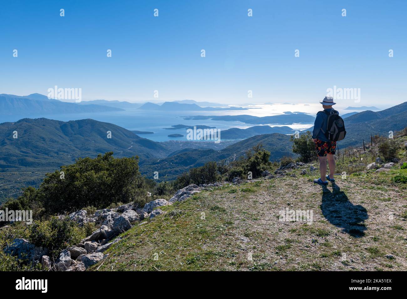 Ein Tourist, der bei einem Wanderurlaub den Panoramablick von einem Berggipfel genießt. Stockfoto