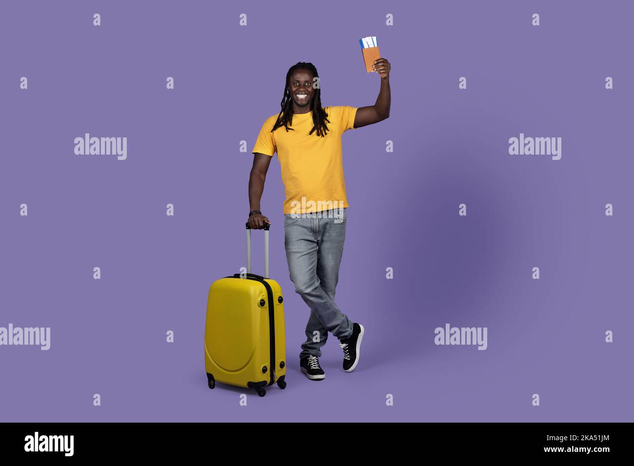 Fröhlicher afroamerikanischer junger Mann, der alleine unterwegs ist Stockfoto