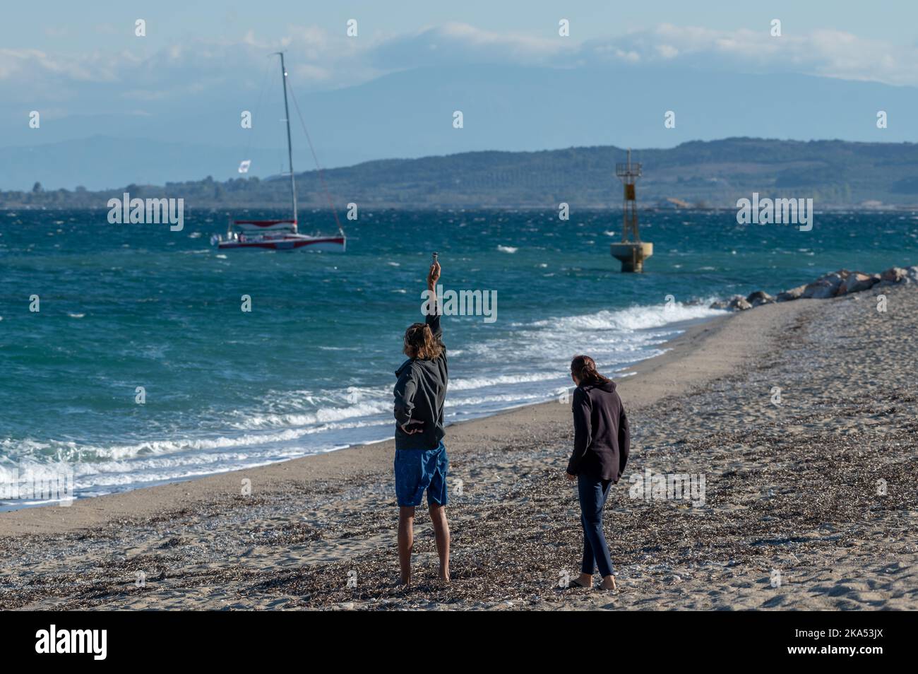 Insel Lefkada. Griechenland-10.15.2022. Ein Paar am Strand testet die Stärke des Windes zum Surfen. Stockfoto