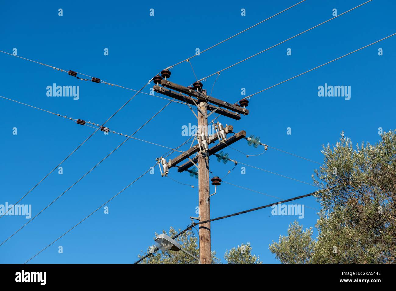 Das obenliegende Stromkabel auf Holzpfosten bringt die Stromversorgung in ländliche Gebiete. Stockfoto