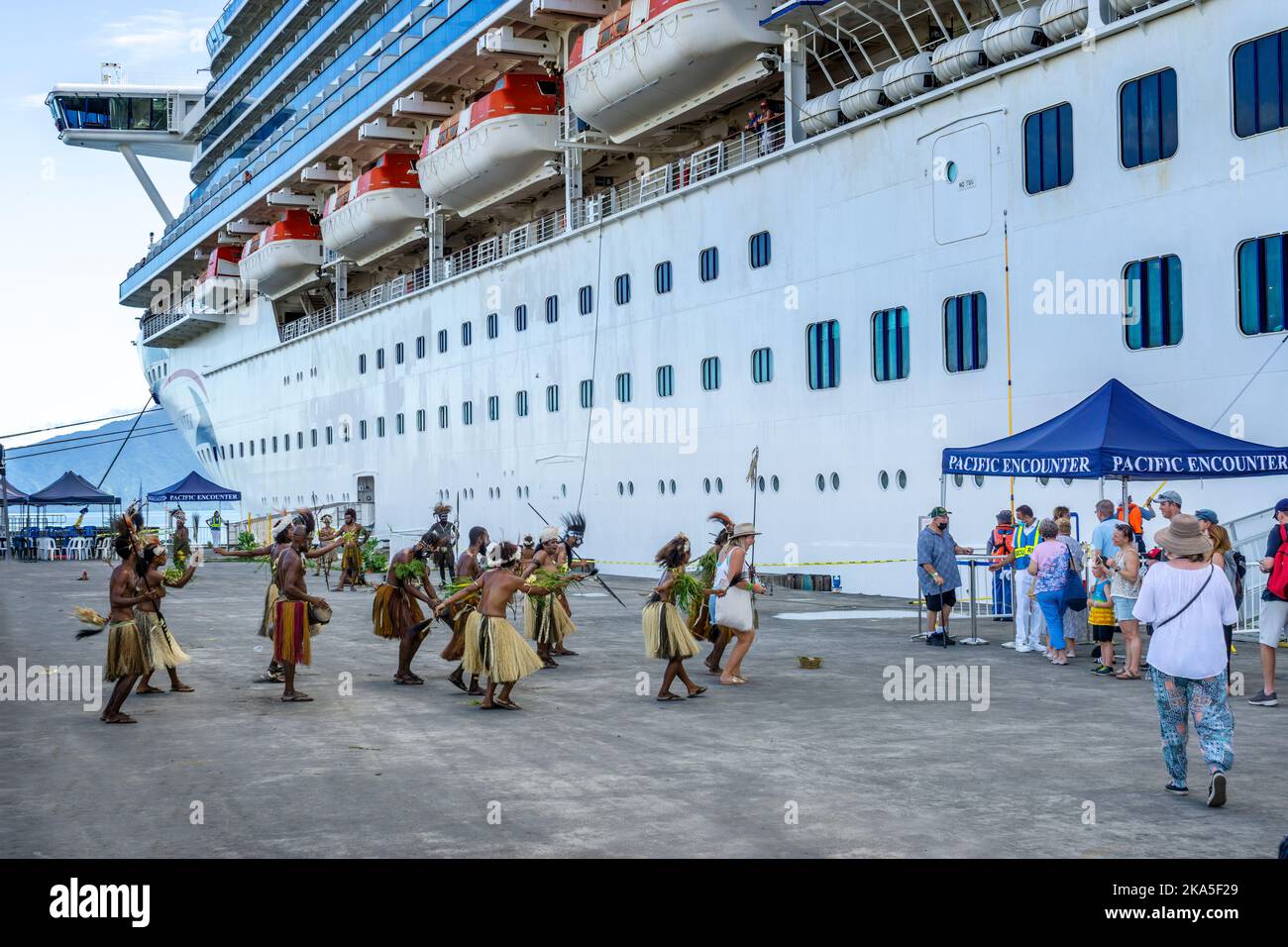 Einheimische Tänzer in traditioneller Tracht begrüßen die Ankunft eines Kreuzschiffs, Alotau, Provinz Milne Bay, Papua-Neuguinea Stockfoto