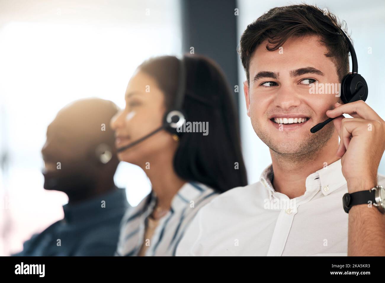 Mann, Berater und Callcenter mit einem Lächeln für Telemarketing, Kommunikation oder Beratung im Büro. Fröhlicher Agent mit einem Lächeln und einem Headset Stockfoto