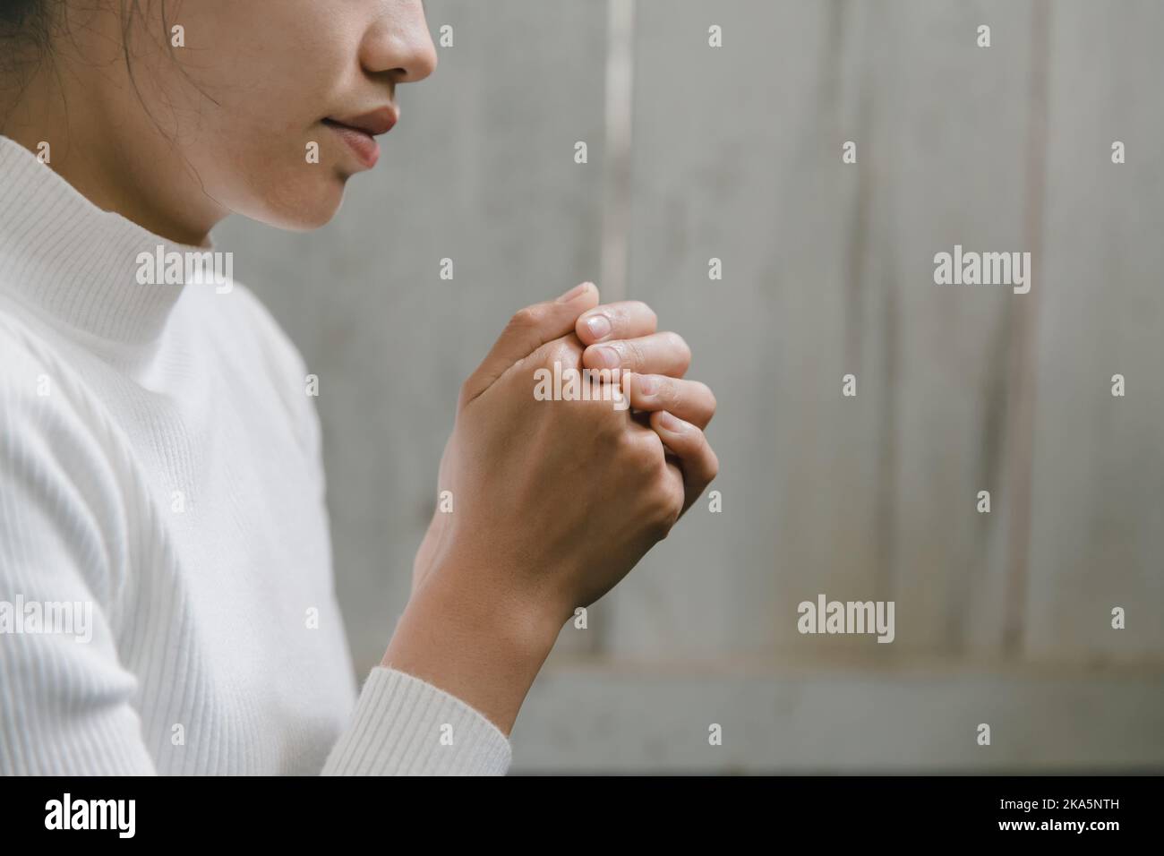 Frau, die für Gott betet, betet mit ihren Händen zusammen an einen liebenden Gott und wir Preisen Gott mit einem leichten Licht in der grünen Natur. Stockfoto