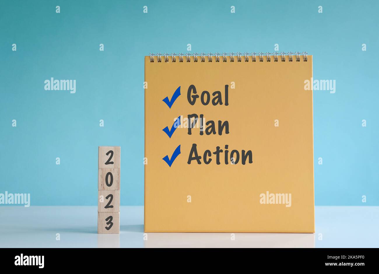 2023 Ziel, Plan und Aktion, Worte auf Holzblock und Kalender. Stockfoto