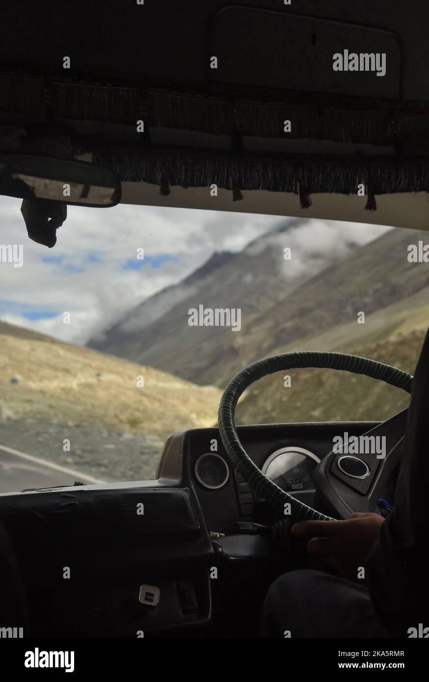 Nicht erkannte Person, die einen Pkw fährt (Tempo-Reisender) auf der Manali-Leh Autobahn mit wunderschönem Blick auf die Berge während der Sommersaison. Stockfoto