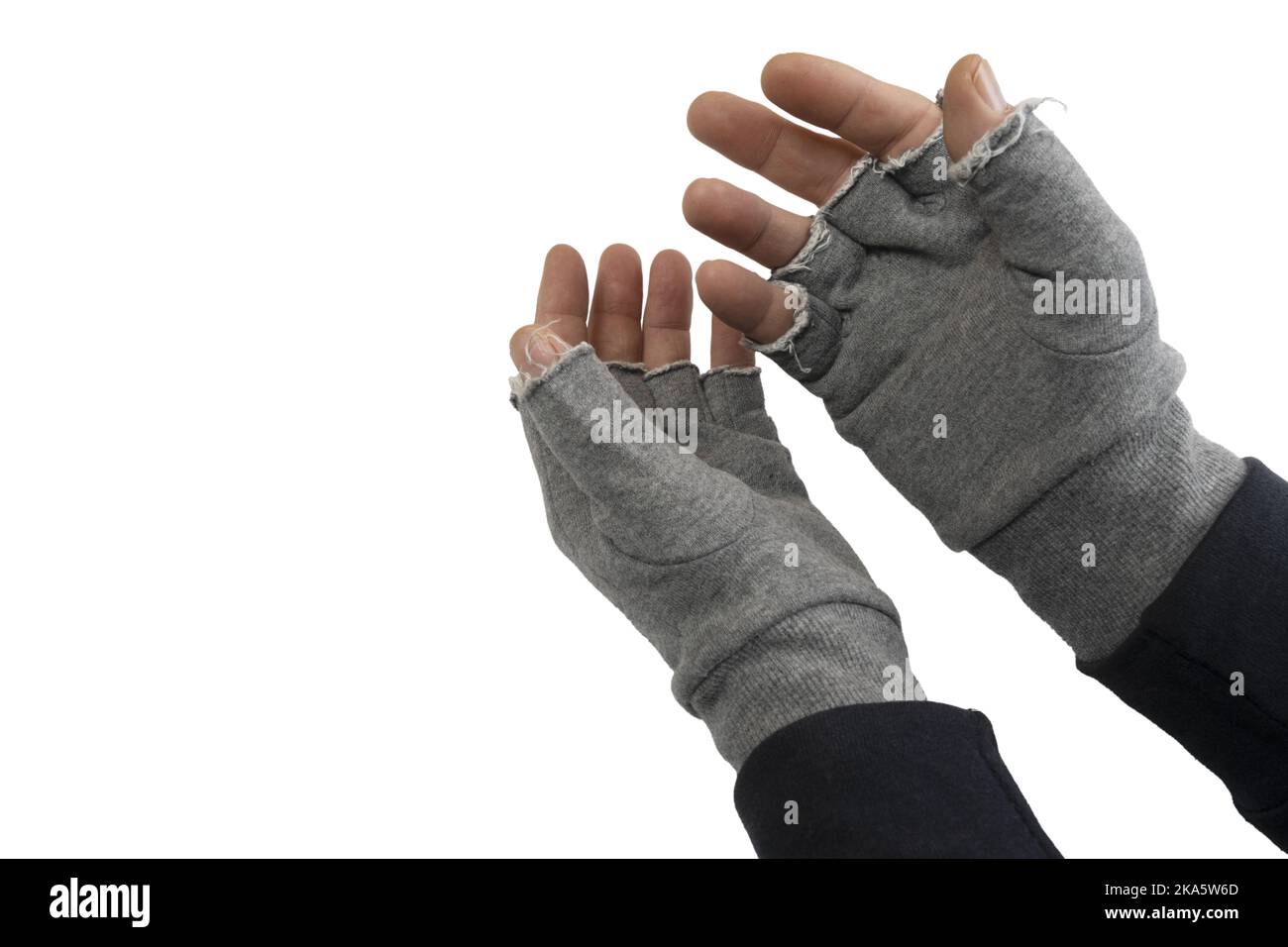 Ein Mann zieht fingerlose Wollhandschuhe auf transparentem Hintergrund an Stockfoto