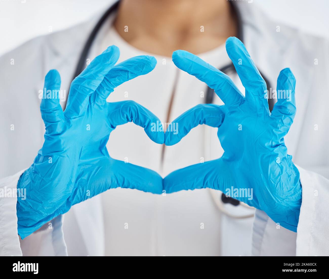 Herz, Arzt und Arzt mit Händen für Unterstützung, Liebe und Gesundheit während der Arbeit in einem Krankenhaus. Medizin, Pflege und Krankenschwester mit Handschuhen und Emoji-Zeichen Stockfoto