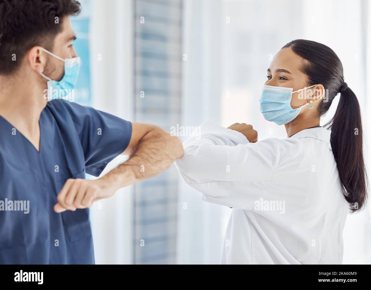 Ärzte, Ellenbogengrüße und Sicherheit bei sozialer Distanzierung, Compliance oder Vorschriften im Krankenhaus. Medizinische Fachkräfte begrüßen mit Waffen für Stockfoto