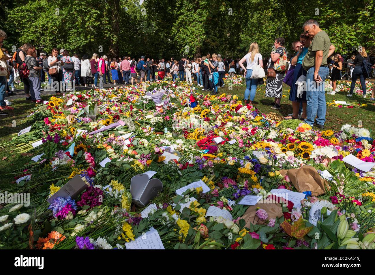 Menschen, die die Blumen-Tribute im Green Park betrachten, die von Trauernden zum Anlass des Todes von Königin Elizabeth II. Hinterlassen wurden. Green Park, London, Großbritannien. 11. September 2022 Stockfoto